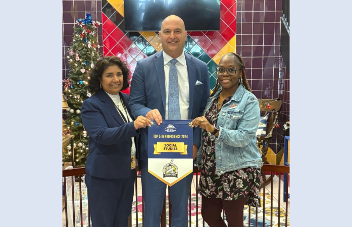 Mrs. Martinez and Ms. Abraham smiling with Dr. Vitti holding a banner 